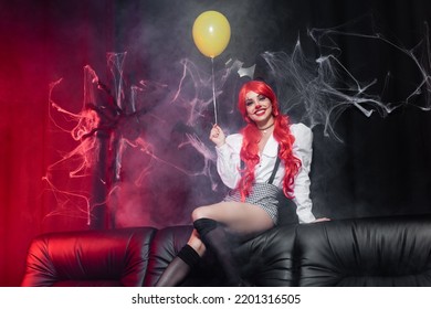 Happy Woman With Clown Makeup And Yellow Balloon Looking At Camera On Dark Background With Spiderweb