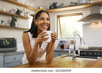 Happy woman, coffee or tea in home kitchen and relax with a smile in the morning at house. Calm young person, smiling at peace and tea drink to wake up to start day with positive joyful thoughts - Powered by Shutterstock