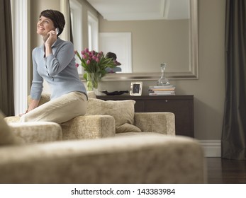 Happy Woman Communicating On Cell Phone In House