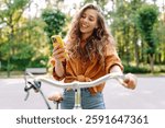 Happy woman commute with her bicycle and use phone in the streets happily. Travel, weekend, relax and lifestyle concept. The way to work
