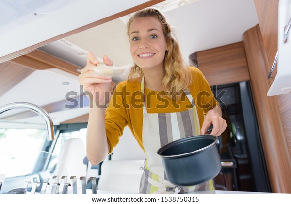 happy woman cooking in\
camper