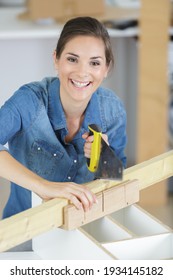 A Happy Woman Cutting Wood