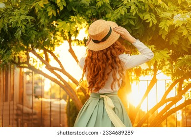 happy woman dancing spinning in vintage straw hat, girl long curly red hair fly wind, retro lady old style white blouse mint skirt dress back rear view. green tree magic sun light flare summer nature - Powered by Shutterstock