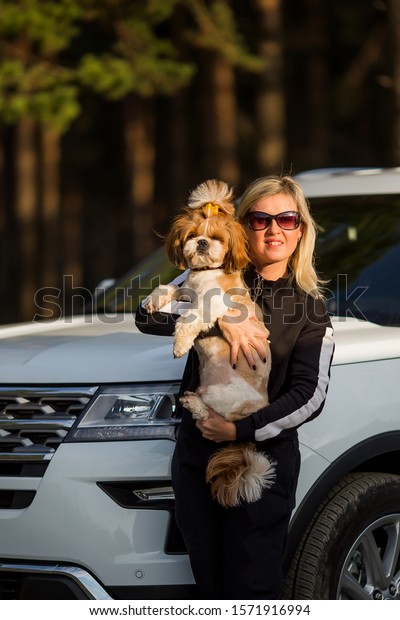 Happy woman and dog in car on summer vacation.\
Dog and human friendship and travel concept. Relax and enjoy the\
tranquility of nature\
together.