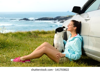 Happy Woman And Dog Sitting Outside Car On Summer Travel Vacation. Pet And Human Friendship And Traveling Concept. Relaxing And Enjoying Peace On Nature Together.