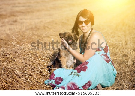 Happy woman with dog in summer sunset