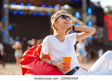 Happy woman drinking beer and having fun at music festival. Beach party, summer holiday, vacation concept. - Powered by Shutterstock