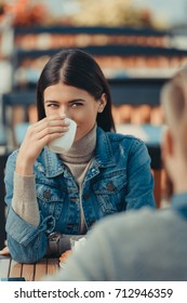 happy woman drinking coffee in cafe with boyfriend