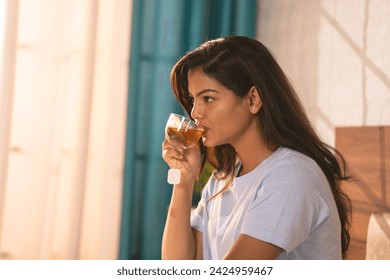 happy Woman drinking Green tea after waking up during morning at bedroom ad weight loss measure - concept of refreshment, antioxidant and carefree living - Powered by Shutterstock