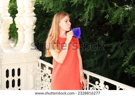 Happy woman drinks drinks healthy mineral thermal water in one of the famous European medical and therapeutic resorts Karlovy Vary