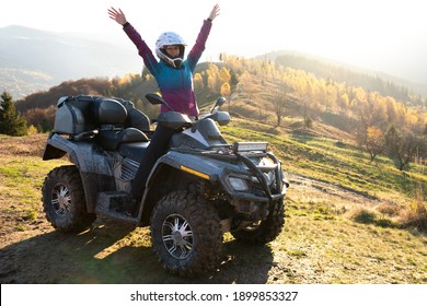 Herzlichen Glückwunsch, Frau Fahrer in Schutzhelm genießen Extrem Reiten auf ATV Quad Motorrad im Sommer Berge bei Sonnenuntergang.