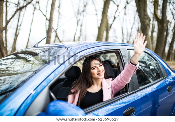 happy\
woman driver sit in the car give salute\
gesture