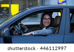 Happy woman driving her new car. High ISO, grainy image.