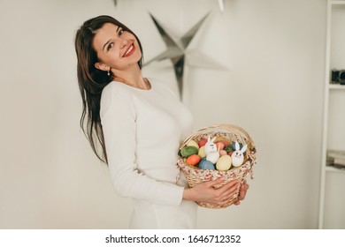 Happy Woman With Easter Basket And Colored Eggs That She Holds In Her Hands On White Backround.