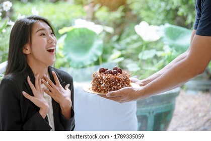 Happy Woman Eat Cake Delicious Sweet Dessert In Chocolate Cafe. Sweet Fancy Cake Got A Surprise Birthday Gift Sugar Tasty Plate In Coffee Shop. Woman Sitting On Cozy Sofa Holding Sweet Cupcake