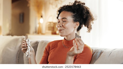 Happy, woman and eating chocolate on sofa for morning snack, enjoy candy and sweet tooth for dessert. Smile, girl and eyes closed with cacao sugar for breakfast peace, comfort food and relax at house - Powered by Shutterstock