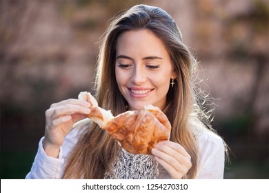 Happy Woman Eating A Croissant Outdoor