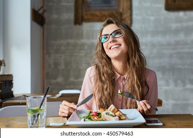 Happy Woman Eating Lunch In Restaurant