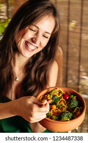 Happy Woman Eating Raw Vegan Casserole Quinoa Salad.