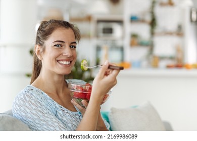 Happy Woman Eating A Salad At Home And Looking At Camera.