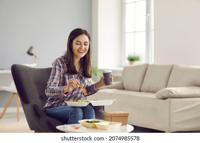 Happy Woman Eating Takeout Lunch At Home. Beautiful Young Girl Sitting In Armchair, Drinking Coffee And Enjoying Healthy Vegetable Salad From Takeaway Food Container. Meal Delivery Service Concept