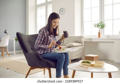 Happy Woman Eating Tasty Lunch From Takeaway Food Container At Home. Beautiful Young Girl Sitting In Armchair And Enjoying Delicious Coffee And Vegetable Salad. Takeout Meal Delivery Service Concept