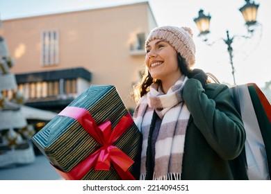 Happy woman enjoying in Christmas shopping during winter day in the city. 