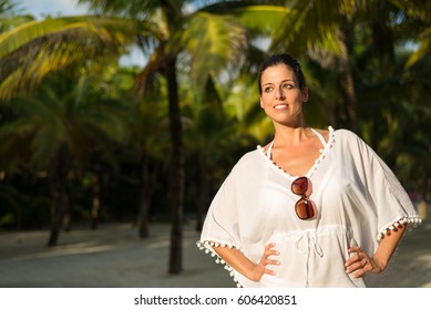 Happy Woman Enjoying Tropical Vacation Travel. Brunette Model Wearing Summer Fashion White Kaftan.