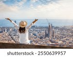 A happy woman enjoys the panoramic view over the skyline of Barcelona, Spain