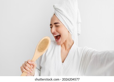 Happy Woman, Facial Emotions, Bath At Home, Good Temper, Singing Song Hold Body Brush As Microphone, Giving Way To Talent And Joy At Free Time In Morning. Young Funny Blonde Lady With Towel On Head