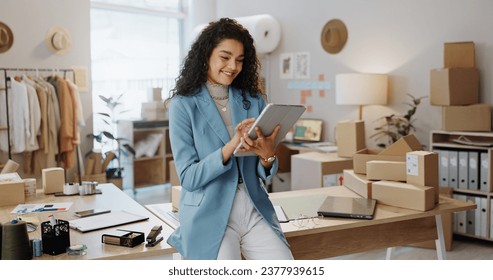 Happy woman, fashion designer and tablet in logistics or small business management at boutique. Female person or entrepreneur smile with technology in supply chain, stock or shipping at retail store - Powered by Shutterstock