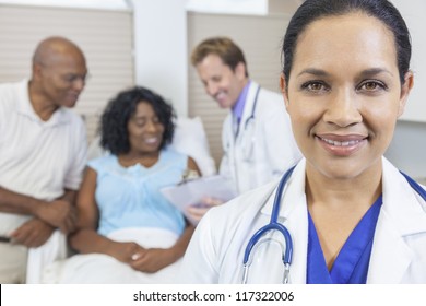 Happy Woman Female Hispanic Latina Doctor In Hospital With Patient Recovering In Hospital Bed & Male Doctor In Background