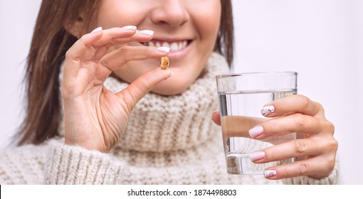 Happy Woman With Fish Oil Capsule Or Vitamin D Supplement. Taking Omega 3 Or D3