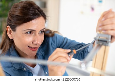 Happy Woman Is Fixing Broken Lamp