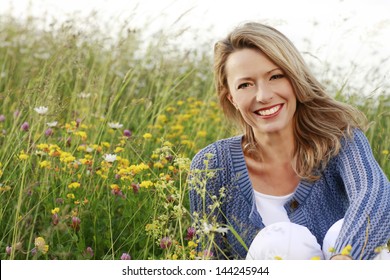 Happy woman with a flower relaxes in the grass with a flower - Powered by Shutterstock