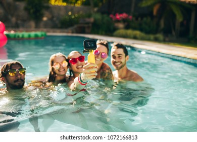 Happy Woman With Friends Taking Selfie In Swimming Pool. Group Of Men And Woman Enjoying Pool Party And Taking Selfie.