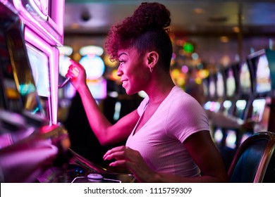 happy woman gambling at casino playing slot machine