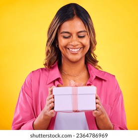 Happy woman, gift box and present for birthday, event or winning against a yellow studio background. Female person smile with prize, giveaway or celebration for surprise, package or ribbon parcel - Shutterstock ID 2364786969