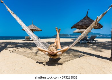 Happy woman in a hammock enjoying vacation on tropical beach - Shutterstock ID 393263032