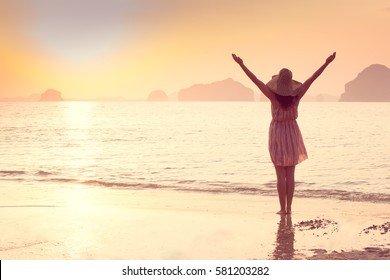Happy Woman in a hat and short dress enjoys in Sea Sunset. In the background hilly karst mountains to the sea, vintage color