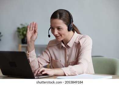 Happy Woman In Headphones Looking At Camera, Enjoying Video Meeting With Friends And Colleagues, Online Virtual Conversation Remote Work Concept. Female Student Sitting At Table And Making Video Call.