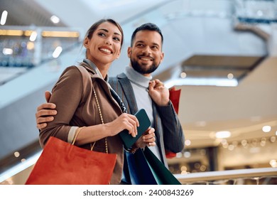 Happy woman and her boyfriend spending a day at shopping mall.  - Powered by Shutterstock