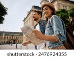 Happy woman and her boyfriends looking at map while exploring the city. Copy space. 