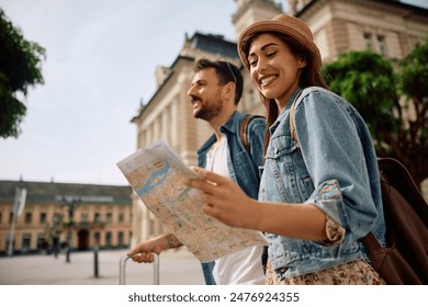 Happy woman and her boyfriends looking at map while exploring the city. Copy space.  - Powered by Shutterstock