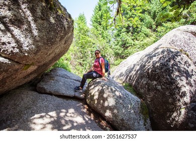 Happy Woman Hiker Portrait , Sitting On Rocks Formation. Summer Day. Adventure In Nature.