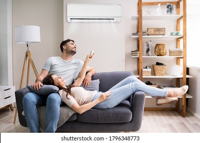 Happy Woman Holding Air Conditioner Remote Control