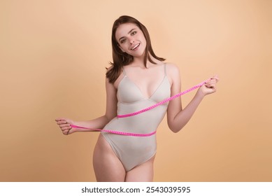 Happy woman holding apple wrapped with measuring tape on waist. Weight loss concept. Dieting and waist exercise. Woman measuring waistline. Fit Girl measuring waist. Sport model measuring waistline. - Powered by Shutterstock