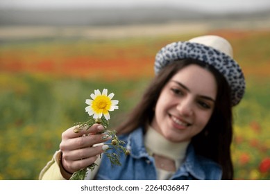 Happy woman holding blooming daisy flower. in spring