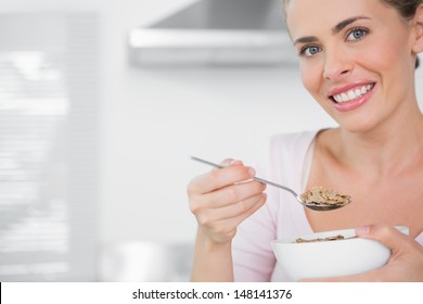 Happy Woman Holding Bowl Of Cereal In Her Kitchen