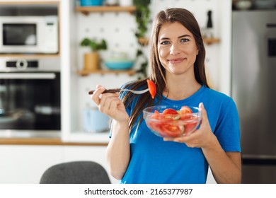 Happy Woman Holding Bowl Of Salad And Looking At Camera.